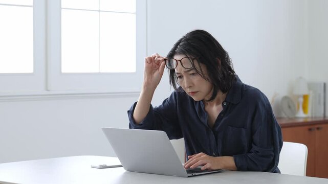 パソコンを使う老眼の中高年女性