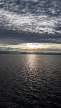 Vertical aerial video of a golden sunset over a calm sea, Moalboal, Cebu, Philippines