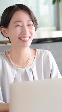 営業で説明する日本人女性ビジネスシーン　商談や プレゼンテーションの打ち合わせ縦動画で大笑いや成功の契約のイメージ