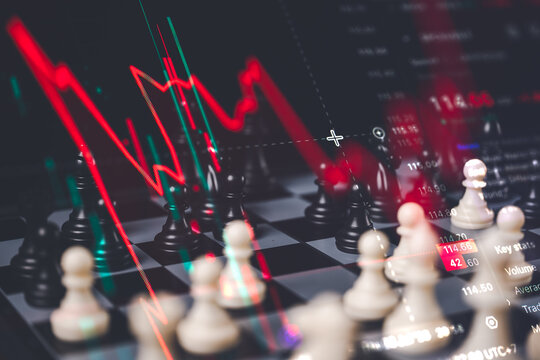 Stock market crash and financial crisis concept showing a chess board with a steep red downward trend line chart overlay
