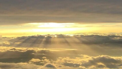 Fototapeta premium Golden Sunbeams Above the Clouds, Aerial Sunset View With Dramatic Crepuscular Rays Breaking Through Cloud Layer