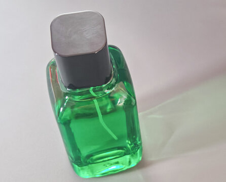 Green glass bottle with transparent liquid and soft natural background, representing skincare, cosmetic, wellness, beauty product packaging, and clean lifestyle concepts