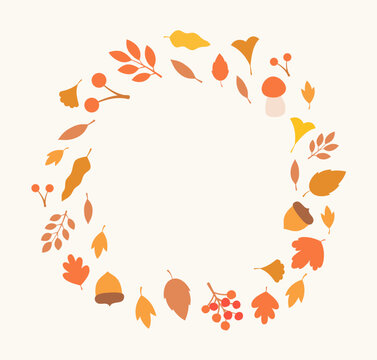 Autumn leaves, acorns, berries, and a mushroom arranged in a circle frame