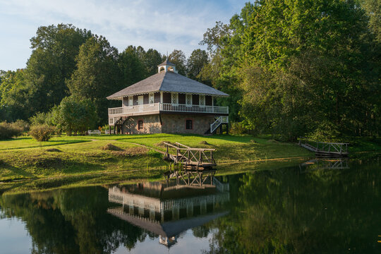 House-Museum of A. P. Hannibal with a reflection in the pond in the Petrovskoye estate of the natural landscape Reserve of A. S. Pushkin on a sunny summer day, Pushkinskiye Gory, Pskov region, Russia