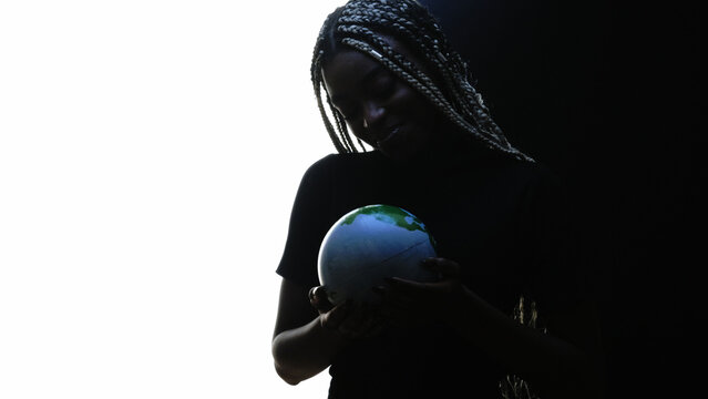 Planet care. Ecology protection. Dark silhouette of happy cheerful woman holding Earth globe in hands isolated on white free space.