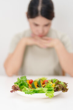 Unhappy woman disgust gesture and Bored to eat fresh organic vegetables. healthy nutrition, weight loss, clean eating, Healthy food eating, Vegan, Wellness, Green dieting and Healthy lifestyle