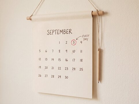 Canvas wall calendar for September with first day of school circled and a wooden pencil