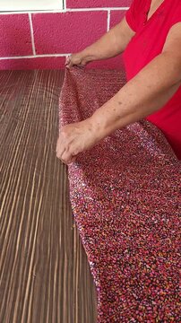 Seamstress Smoothing and Arranging Fabric on Cutting Table