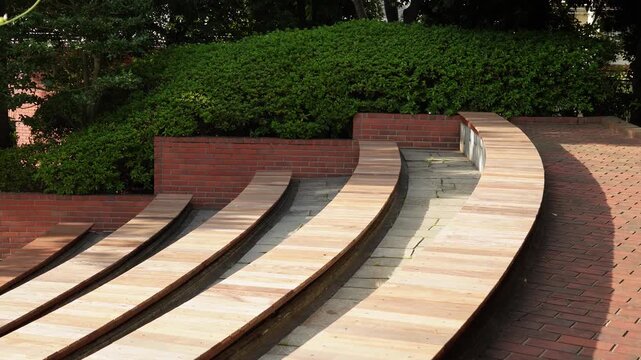 初夏の日差しが降り注ぐ洋風庭園の野外ステージと新緑の風景