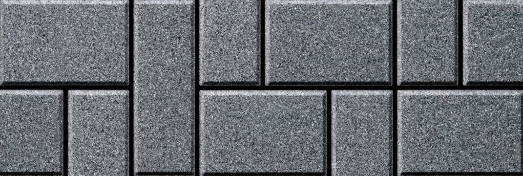 Textured gray interlocking rectangular paving stones arranged in a pattern