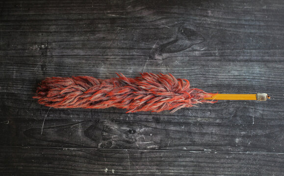 small maroon duster on a black board.