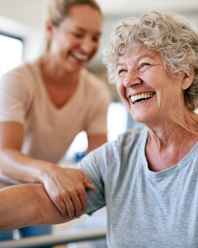 Warm light illuminates two women. One smiles brightly, embracing joy. The other offers gentle support. Their connection radiates care. Perfect for wellness or senior care scenes