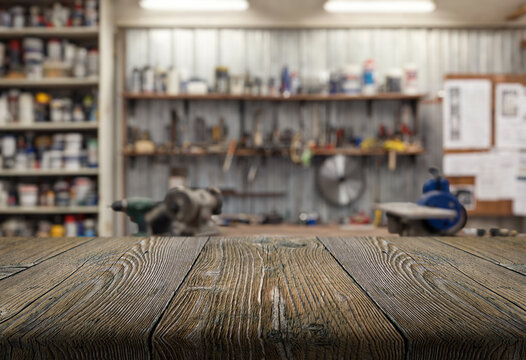 craft workshop or garage interior with tools and empty wooden table top on foreground