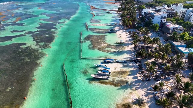 Aerial view of anchored boats and palm trees on tropical Mahahual beach shore in Mexico
