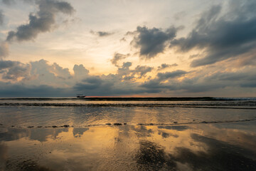 Fototapeta premium Golden Sunset over Tropical Beach with Fishing Boat and Cloud Reflections