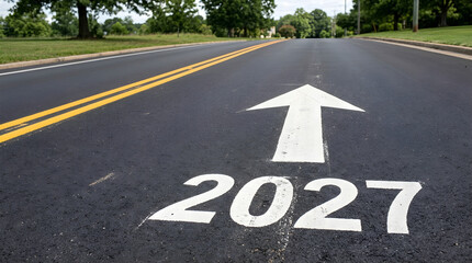 Fototapeta premium Year 2027 painted on an asphalt road with a direction arrow. This image represents future planning and new business goals.