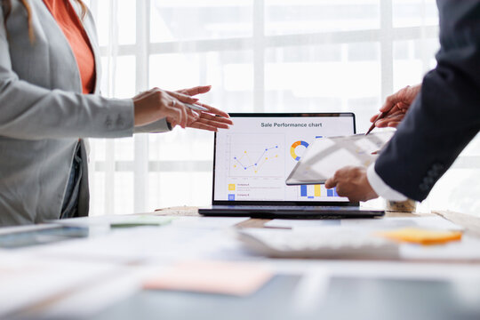 Business professionals engaging in collaborative data analysis and sales strategy
