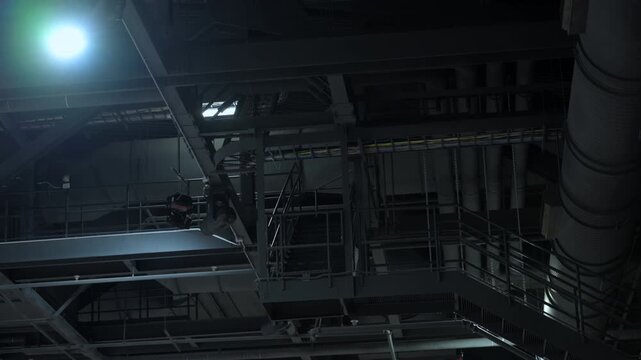Metal black roof trusses and ceiling structure inside a large hall or center. Industrial steel framework 