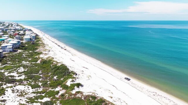 Panoramic drone fly over the white sandy Cape San Blas beach with emerald Gulf water and dunes during a sunny daytime, Florida, US