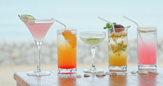 Tropical cocktails sitting on wooden beach table, seashore background with shells, summer vacation and tourism hospitality marketing