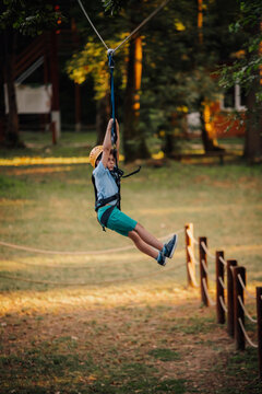 Young boy enjoying zip line adventure park activity