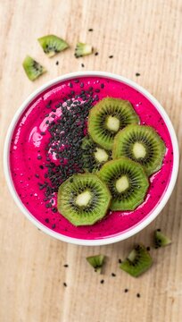 Healthy dragon fruit smoothie bowl with fresh kiwi slices and chia seeds.