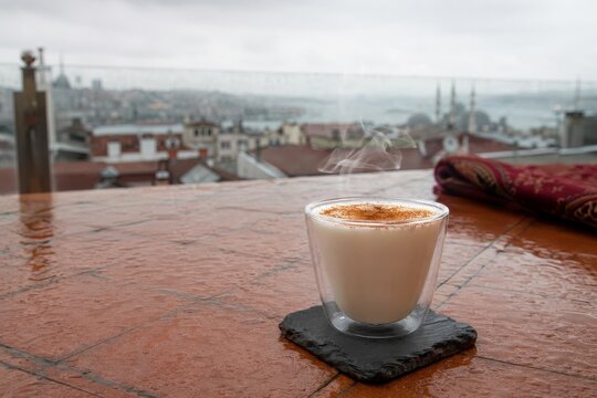 Taza de salep caliente con vista de una ciudad al fondo