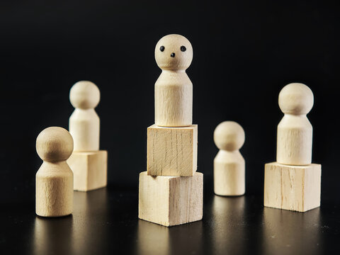 Wooden figures symbolize individuality and standing alone against group pressure