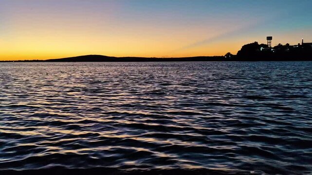 Sunset Sky with Crepuscular Rays Over Calm Water Surface