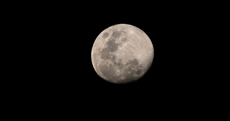Full moon shining in a clear black night sky showing detailed lunar craters and surface texture. Close-up telephoto shot of the moon during night. © TravelMedia