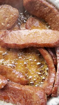 Sizzling sucuk in the pan releasing rich flavors and crispy edges in this vertical Adobe edit video.