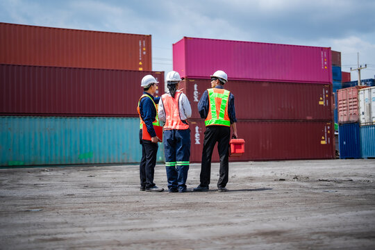 Logistics team inspecting container storage area while reviewing cargo movement across shipping terminal. Freight coordination, transportation operations, port logistics, supply chain planning.