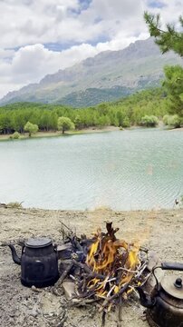 Daytime Camping at a Misty Lakeside with a Cozy Campfire and Brewing Tea