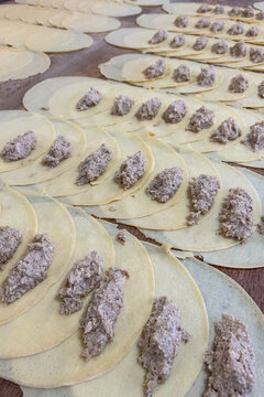 Preparation of semi-finished products Crepes filled with dough sheets and filling placed on a wooden surface at a kitchen setting