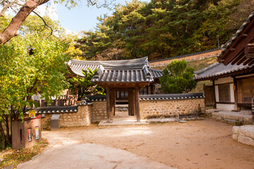 Fototapeta premium Traditional Korean Hanok Courtyard Featuring Earthen Walls, Tiled Gates, and Timber Post-and-Beam Construction