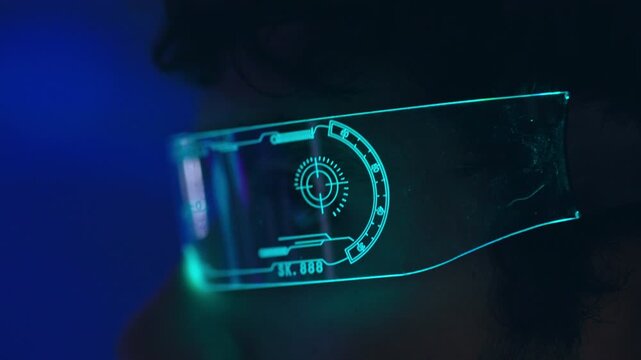 Futuristic visor face person with neon light reflection blue dark studio eyewear transparent digital interface holographic overlay smart technology cyberpunk mood dramatic shadow