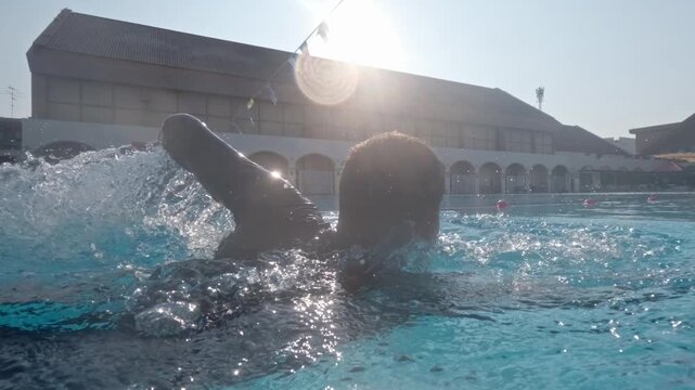 Athletic sportsman swimming in outdoors pool during fitness training