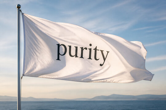 A white flag with "purity" written on it flies against a blue sky over the ocean.