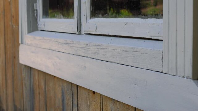 Close-up of an old wooden window frame with weathered paint and aged texture. Ideal for architecture, restoration, vintage, and historical building concepts.