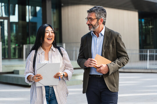 University Professor And Asian Female Student Walking And Talking After Class