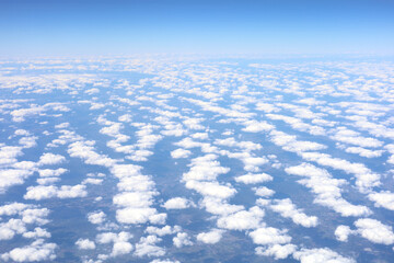 Fototapeta premium Aerial view of a vast field of white cumulus clouds under a clear blue sky