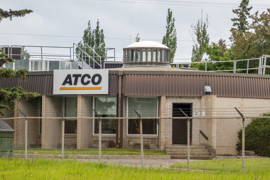 Calgary, Alberta, Canada. July 26, 2026. Wide view of ATCO facility building behind chain link fence on an overcast day.