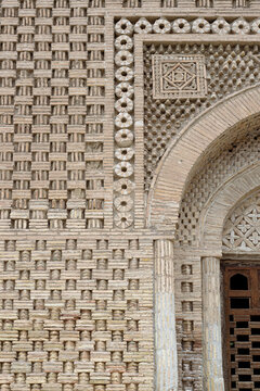 Ornate brickwork detail of the Ismail Samani Mausoleum in Bukhara showing intricate geometric patterns and arch. Ideal for architectural studies, heritage publications, and travel media.