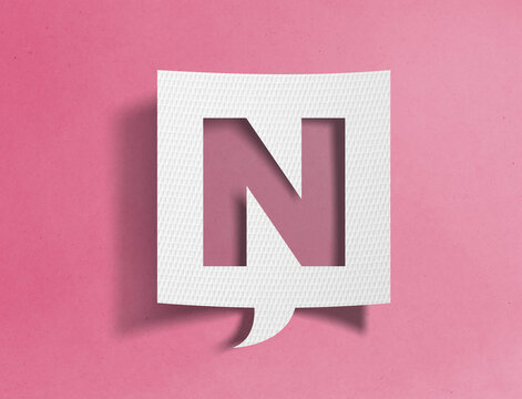 Paper speech bubble with letter N cutout on pink background, alphabet and typography concept