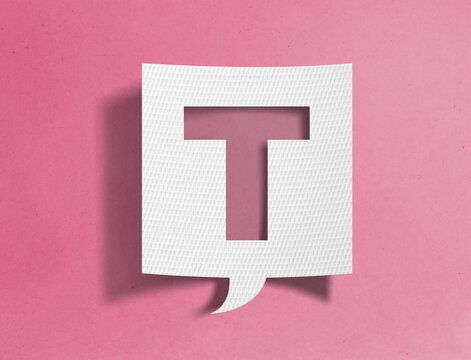Paper speech bubble with letter T cutout on pink background, alphabet and typography concept