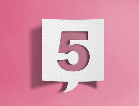 Paper speech bubble with number five cutout on pink background, ranking and sequence concept