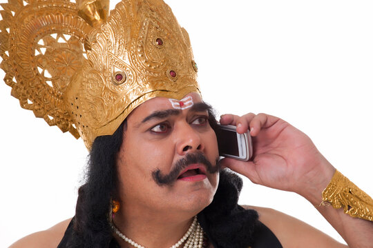 Man dressed as Raavan talking on a mobile phone 
