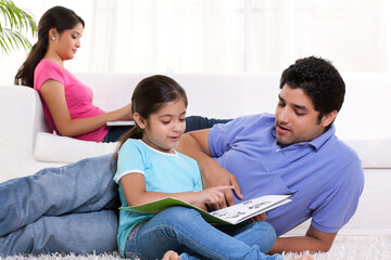 Obraz premium Young father assisting her daughter with woman in the background 