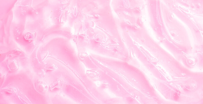 Cosmetic gel, serum, clear sample with a pink tint, close-up. Liquid cream with a foaming texture. Gel-like texture of a cosmetic product. Liquid cosmetic lotion for skin care.