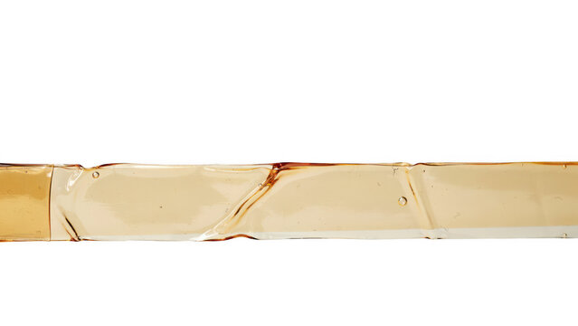 Closeup of a stream of golden liquid amber honey or syrup isolated on transparent background